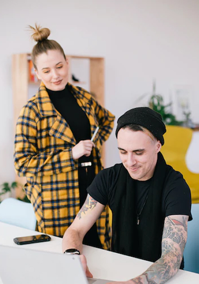 a man and a woman looking at a laptop